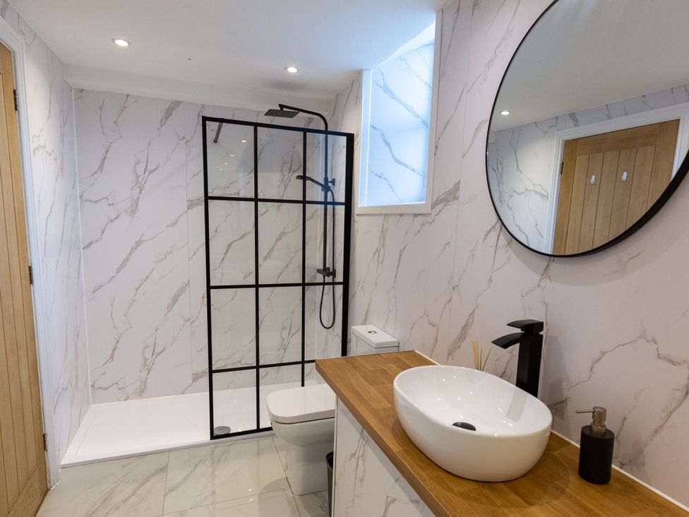 A bathroom with a shower, washbasin, and toilet at Moorsholm View Saltburn-by-the-Sea