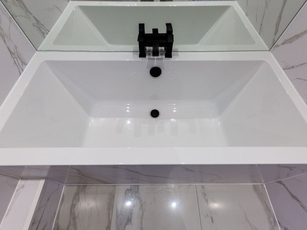 A sink with a black faucet and a mirror in the bathroom at Moorsholm View Saltburn-by-the-Sea
