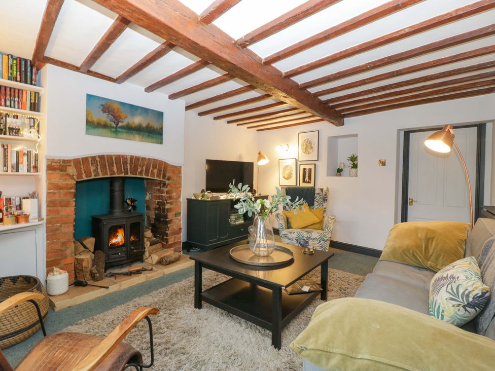 A living room with a sofa and fireplace at Elm Cottage Moreton-In-Marsh