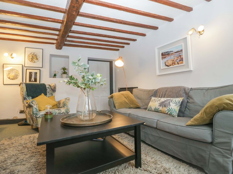 A living room with a sofa, armchair and coffee table at Elm Cottage in Moreton-In-Marsh