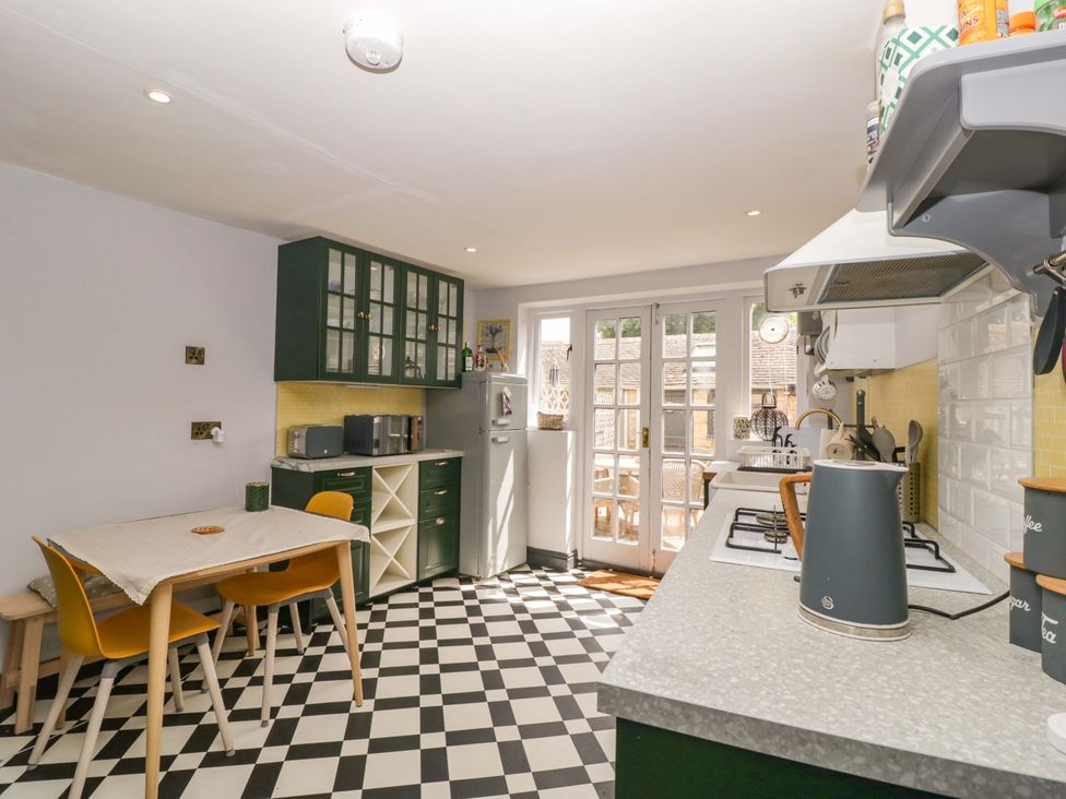 A kitchen with a table and chairs at Elm Cottage in Moreton-In-Marsh