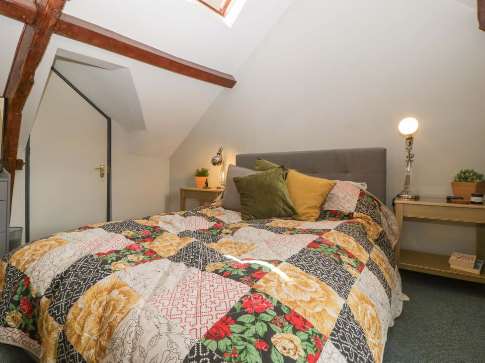 A bedroom with a bed and bedside table at Elm Cottage in Moreton-In-Marsh