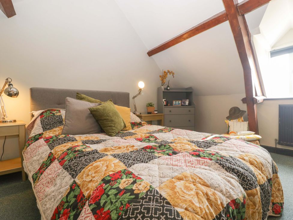 A bedroom with a bed and dresser at Elm Cottage in Moreton-In-Marsh