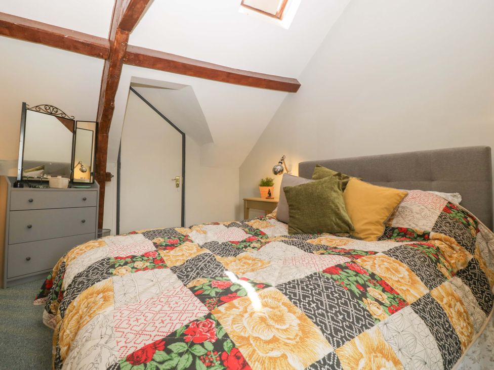 A bedroom with a bed and dresser at Elm Cottage in Moreton-In-Marsh