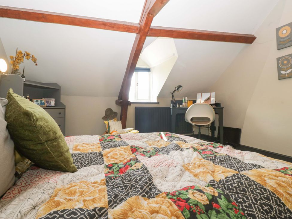 A bedroom with a bed and desk at Elm Cottage Moreton-In-Marsh