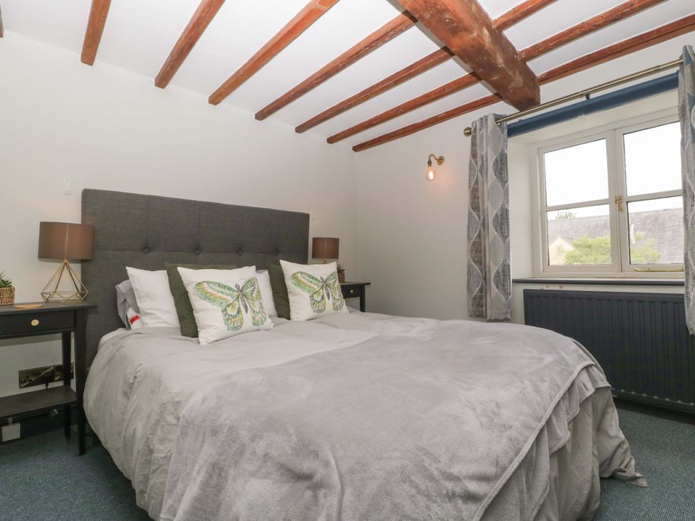A bedroom with a bed and lamps at Elm Cottage in Moreton-In-Marsh