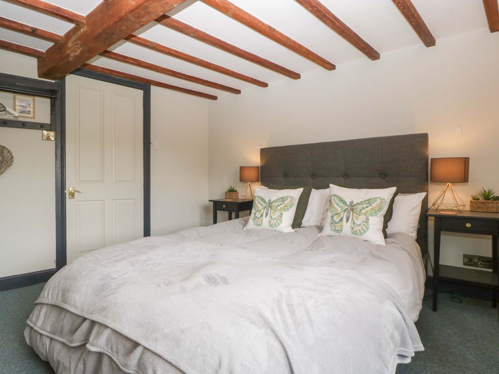 A bedroom with a bed and nightstands at Elm Cottage in Moreton-In-Marsh