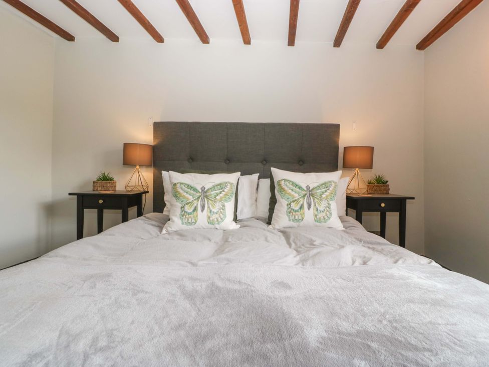 A bedroom with a bed and bedside tables at Elm Cottage in Moreton-In-Marsh