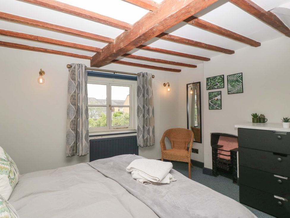 A bedroom with a bed and window at Elm Cottage Moreton-In-Marsh