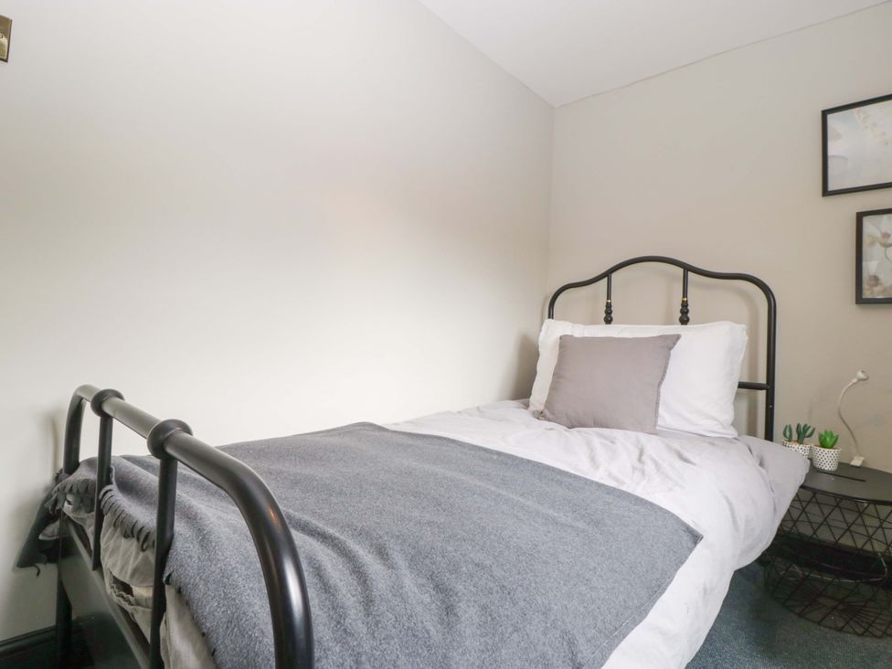 A bedroom with a bed and nightstand at Elm Cottage Moreton-In-Marsh