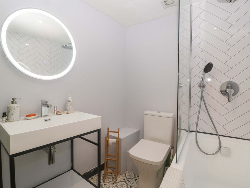 A bathroom with a sink, toilet, and shower at Elm Cottage in Moreton-In-Marsh