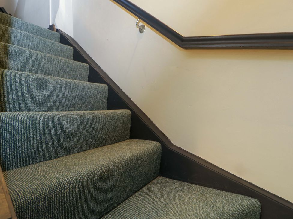 A staircase with carpet and a handrail at Elm Cottage in Moreton-In-Marsh