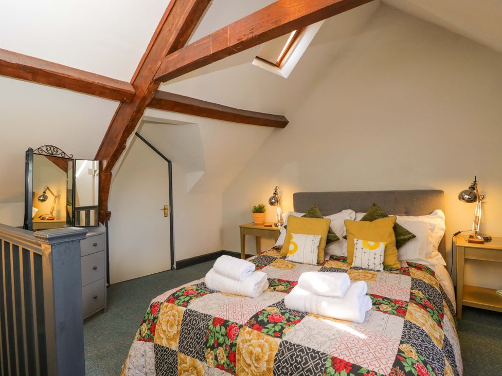 A bedroom with a bed and mirror at Elm Cottage Moreton-In-Marsh