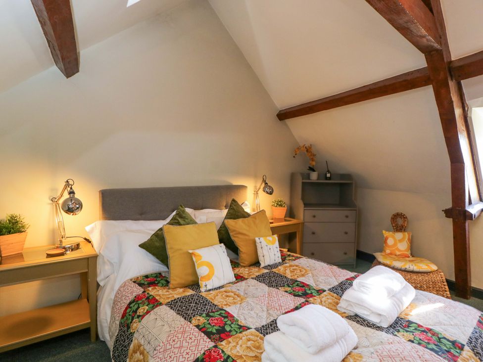 A bedroom with a bed and bedside furniture at Elm Cottage Moreton-In-Marsh