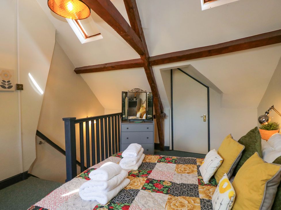 A bedroom with a bed and dresser at Elm Cottage Moreton-In-Marsh