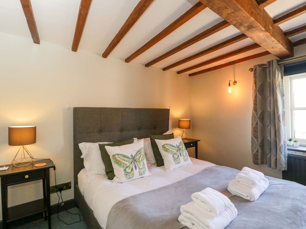 A bedroom with a bed and nightstands at Elm Cottage, Moreton-In-Marsh
