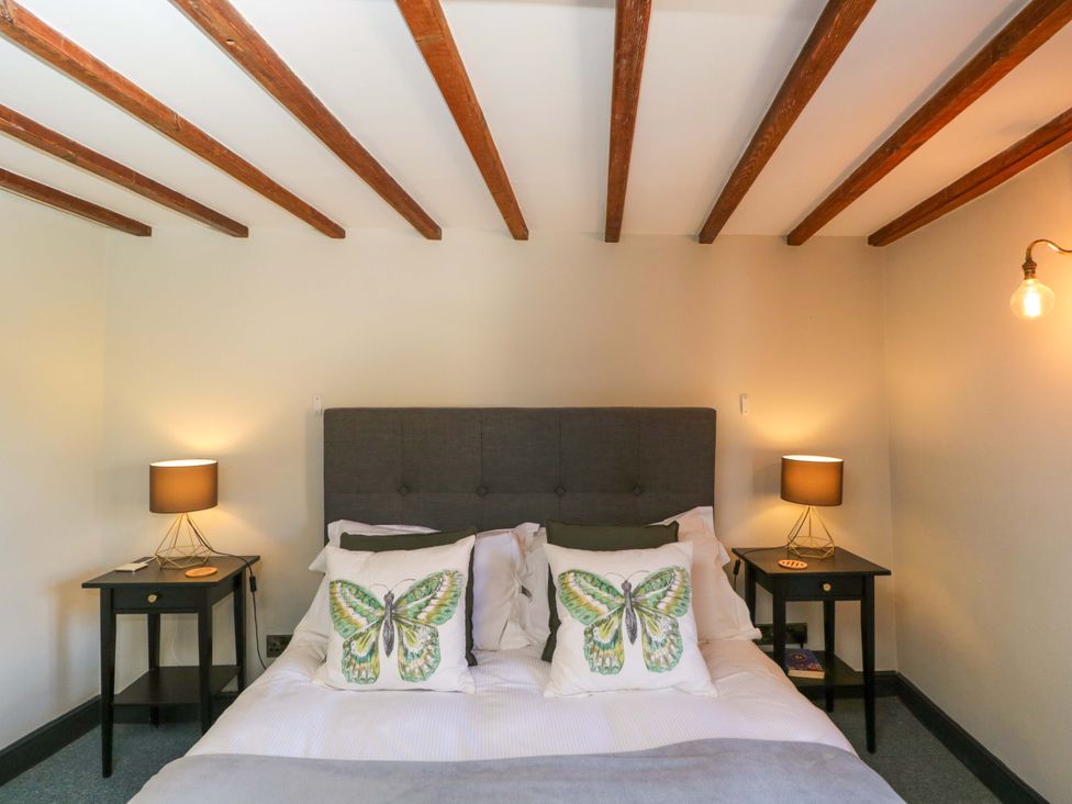 A bedroom with a bed and nightstands at Elm Cottage in Moreton-In-Marsh