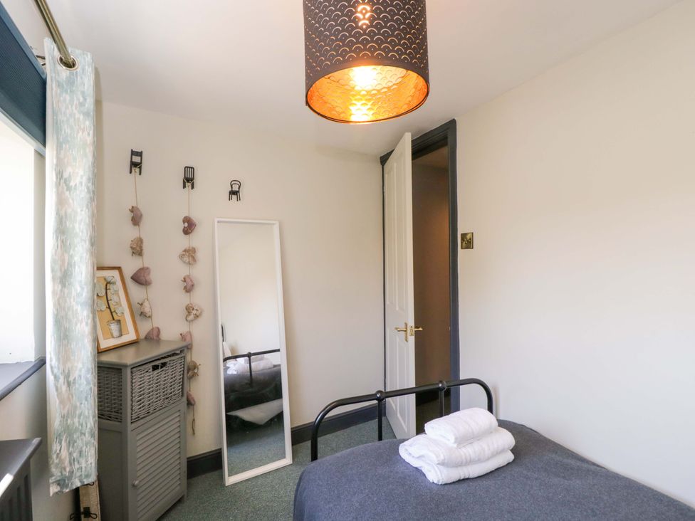 A bedroom with a bed and mirror at Elm Cottage in Moreton-In-Marsh