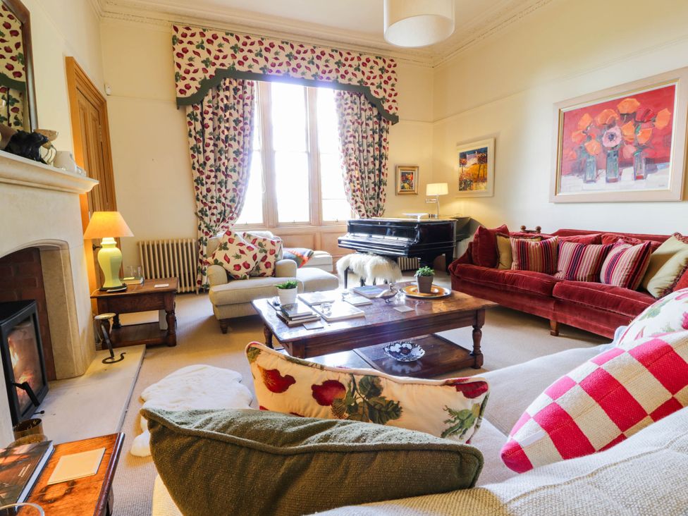 A living room with a piano and seating area at Eagle Glen Manor House in Blairgowrie