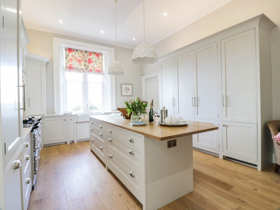 A kitchen with an island and cabinets at Eagle Glen Manor House in Blairgowrie