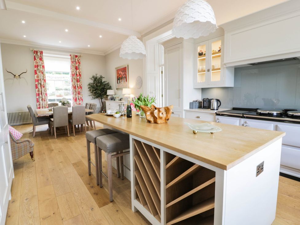 A kitchen with an island and dining area at Eagle Glen Manor House in Blairgowrie