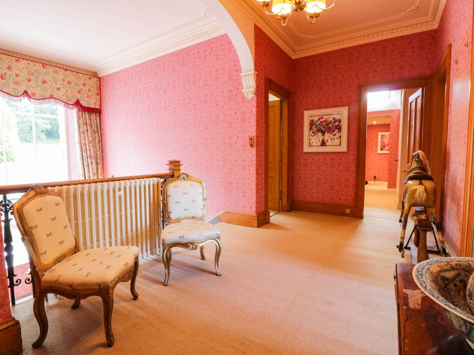 A hallway with two chairs and artwork at Eagle Glen Manor House in Blairgowrie