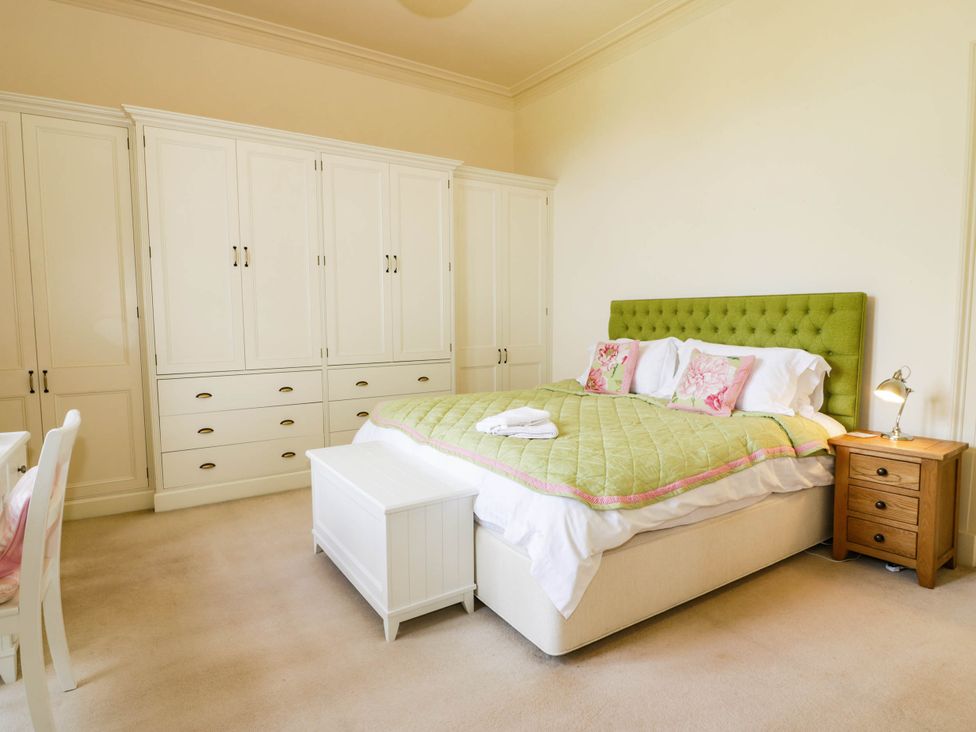 A bedroom with a bed and wardrobe at Eagle Glen Manor House in Blairgowrie