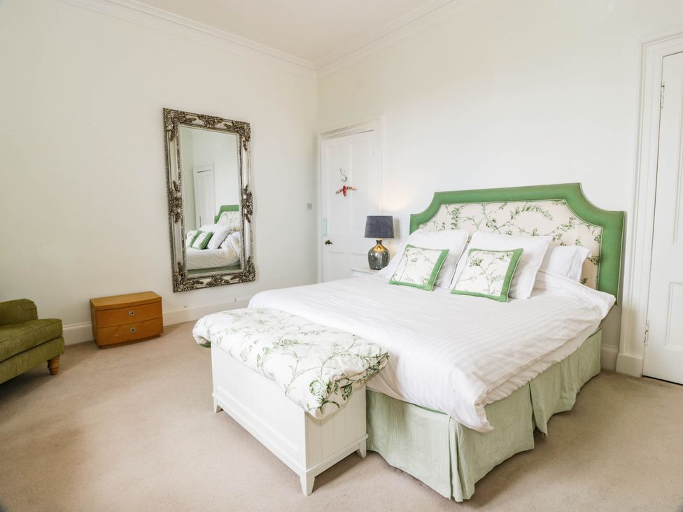 A bedroom with a bed and a mirror at Eagle Glen Manor House in Blairgowrie