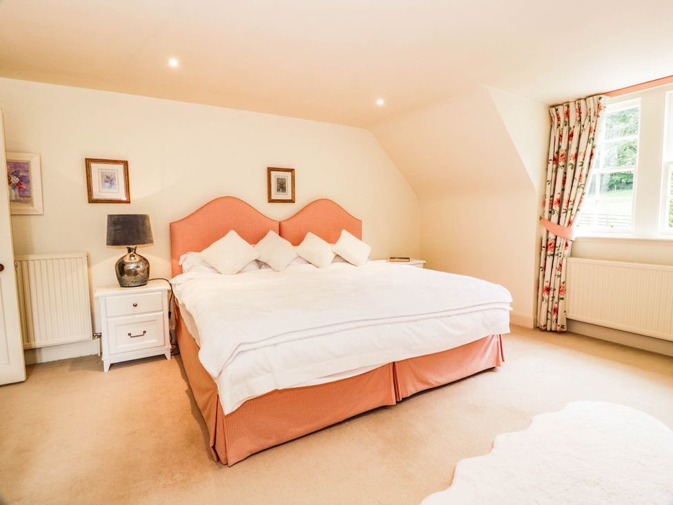 A bedroom with a bed and bedside table at Eagle Glen Manor House in Blairgowrie