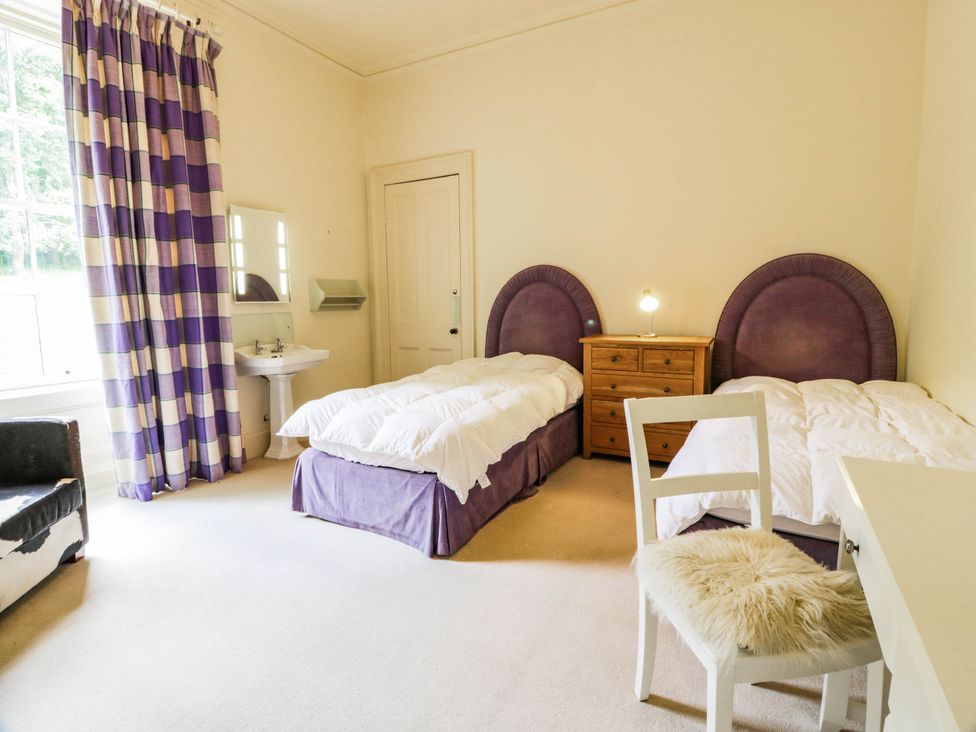 A bedroom with two beds and a dressing table at Eagle Glen Manor House in Blairgowrie