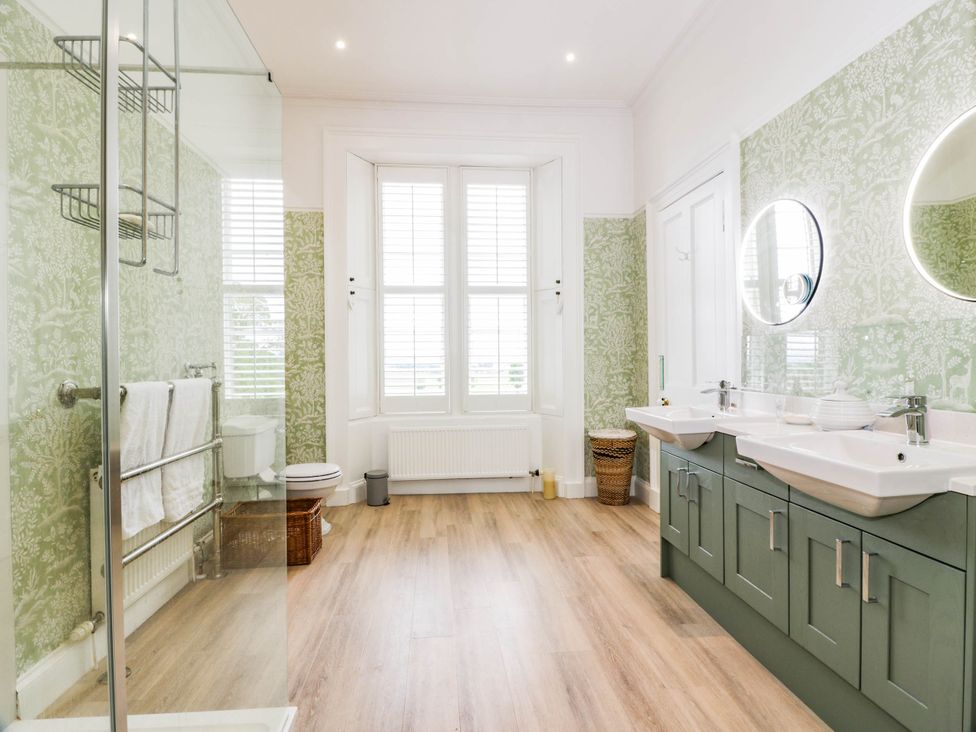 A bathroom with a shower, toilet, and double sink at Eagle Glen Manor House in Blairgowrie