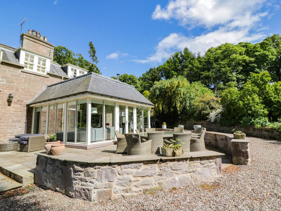 An outdoor seating area with a conservatory and furniture at Eagle Glen Manor House in Blairgowrie