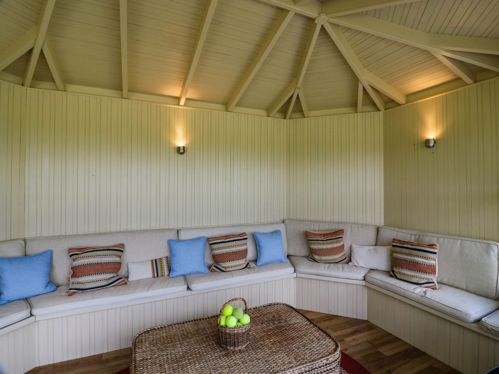 A snug area with a circular sofa and a basket of fruit at Eagle Glen Manor House in Blairgowrie