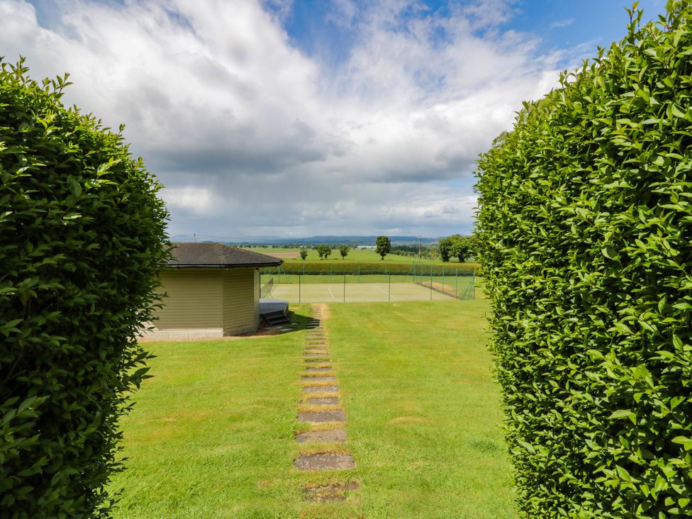A pathway leading to a tennis court at Eagle Glen Manor House in Blairgowrie