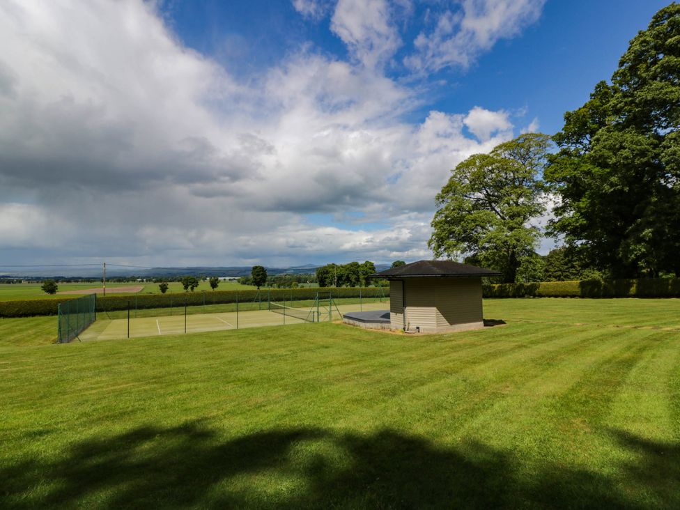 An outdoor area with a tennis court and an outbuilding at Eagle Glen Manor House in Blairgowrie
