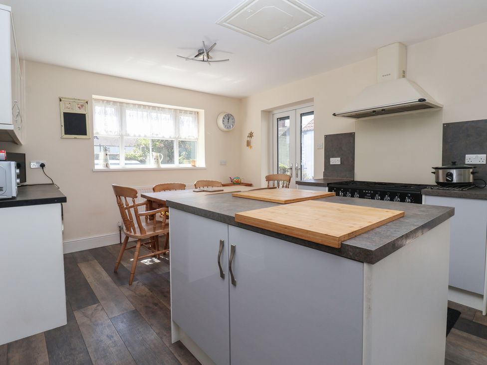 A kitchen with an island and wooden chairs at 4 Queen Street in Withernsea