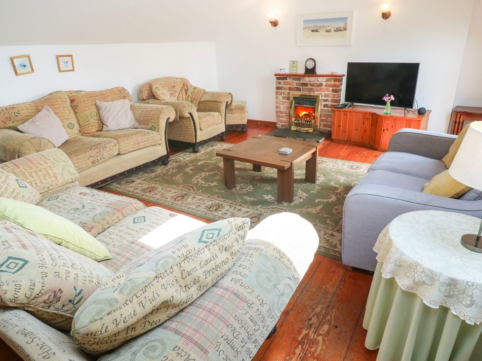 A living room with sofas and a television at The Cottage in St. Ives