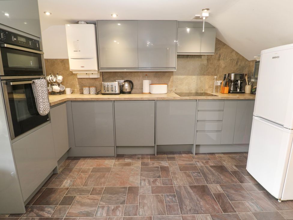 A kitchen with appliances and cabinets at The Cottage in St. Ives