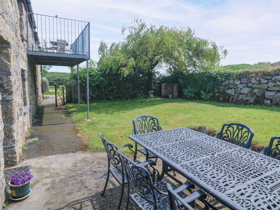A garden with a table and chairs outside at The Cottage in St. Ives
