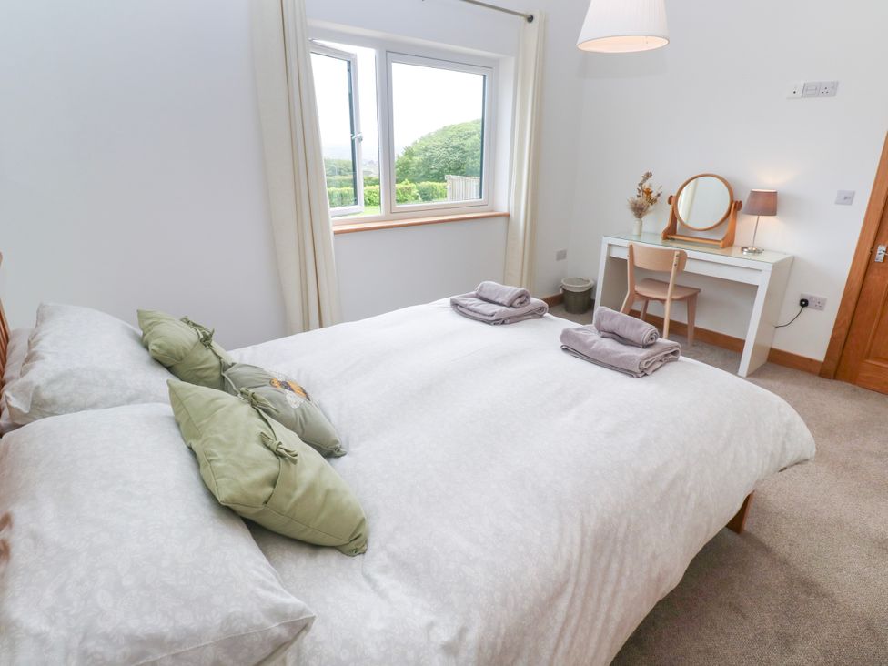 A bedroom with a bed, desk and chair at Swallows Nest in St. Ives