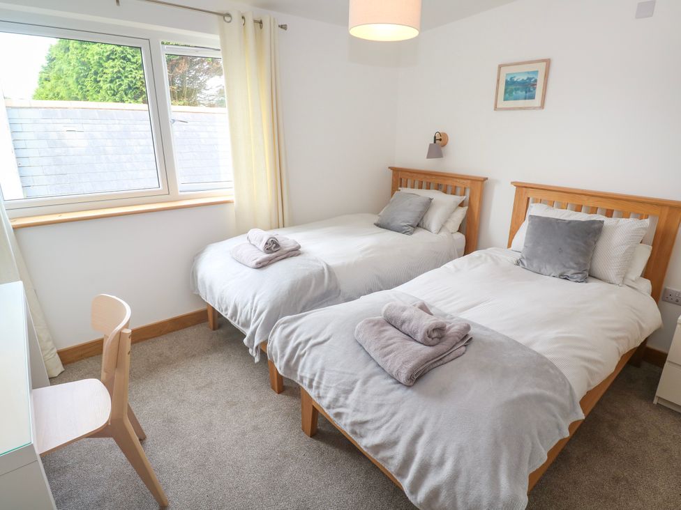 A bedroom with two twin beds and a desk at Swallows Nest in St. Ives