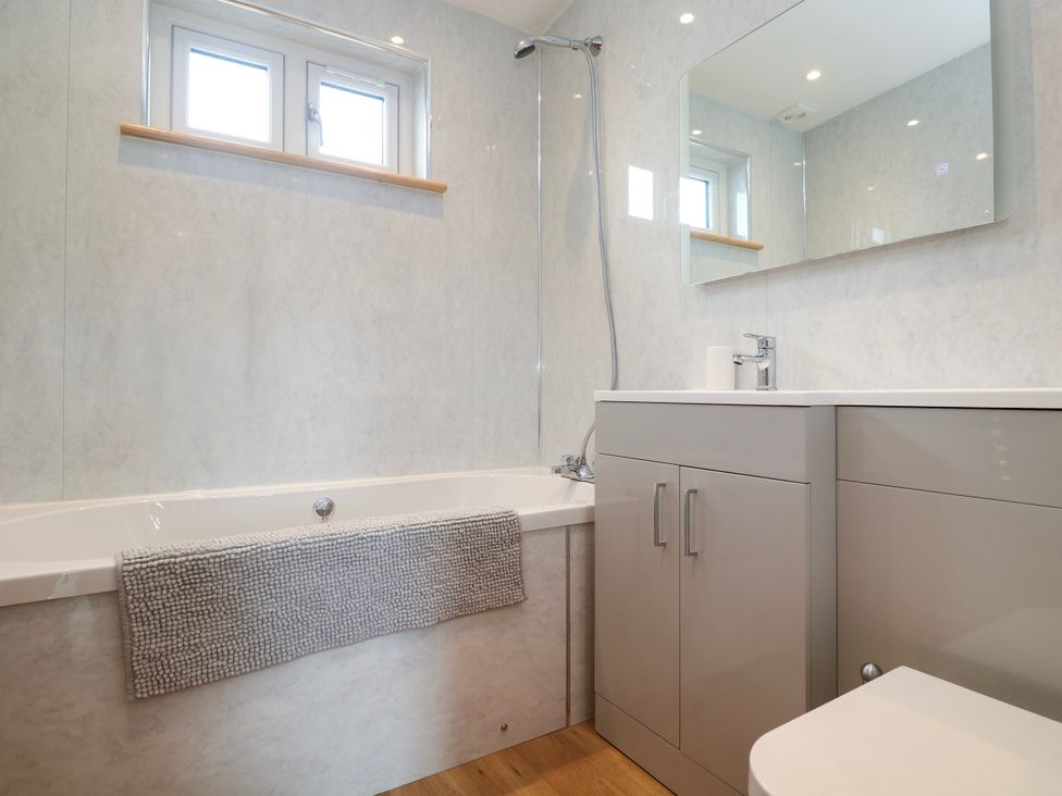A bathroom with a bath tub, sink, and toilet at Swallows Nest in St. Ives