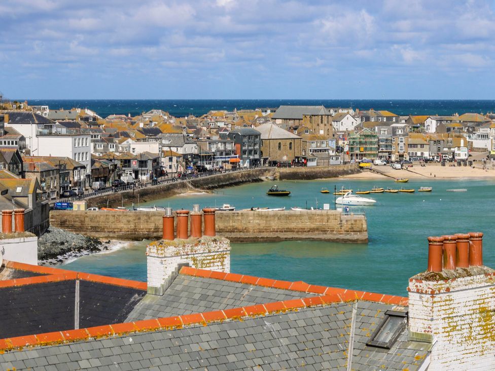 A view of buildings and boats by the water at Swallows Nest in St. Ives