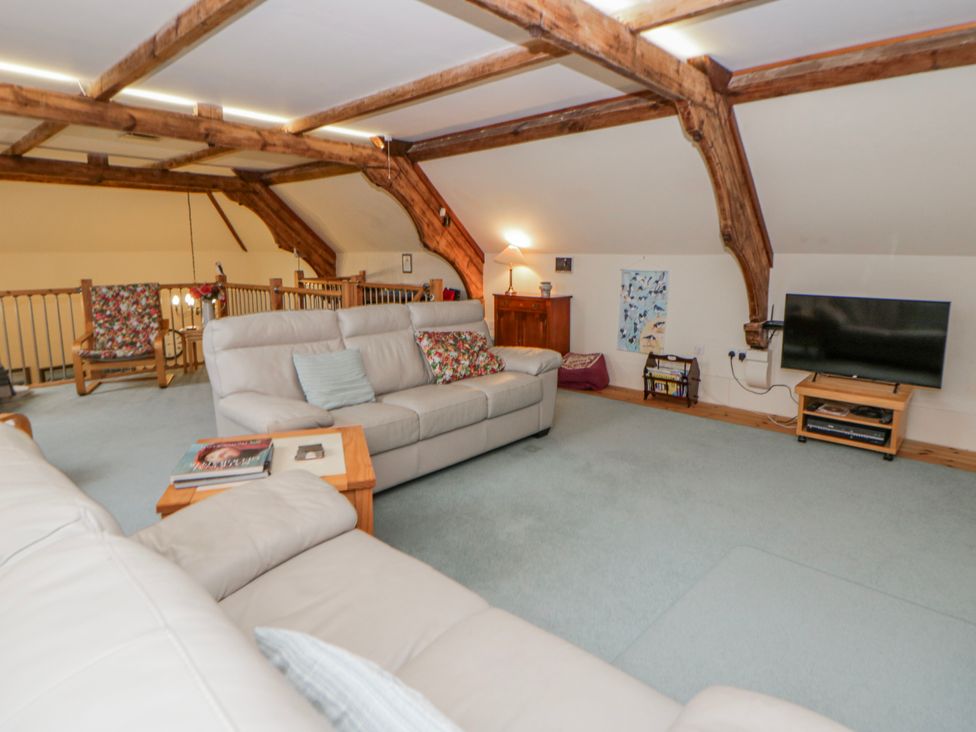 A living room with a sofa and television at Yr Hen Ysgoldy