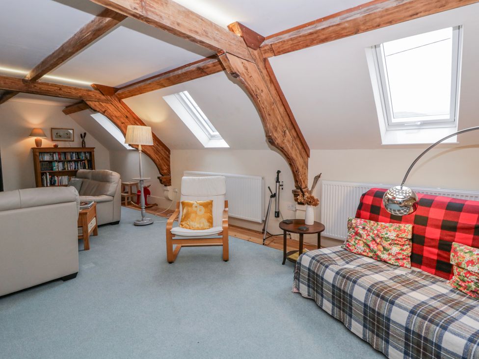 A living room with furniture and a bookshelf at Yr Hen Ysgoldy