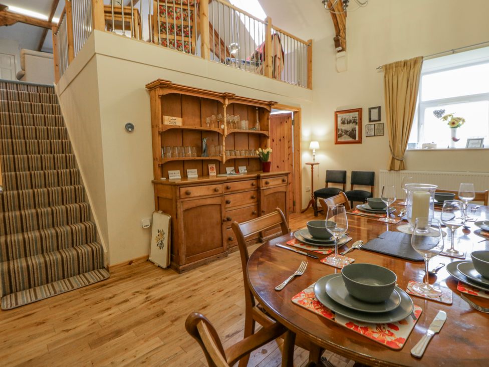 A dining room with a wooden table and chairs at Yr Hen Ysgoldy