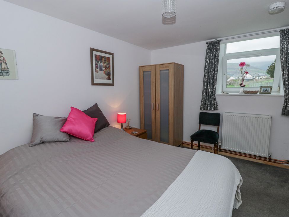 A bedroom with a bed and window at Yr Hen Ysgoldy