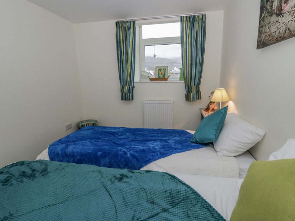 A bedroom with two beds and a window at Yr Hen Ysgoldy