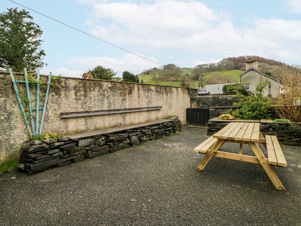 An outdoor area with a wooden table and bench at Yr Hen Ysgoldy 