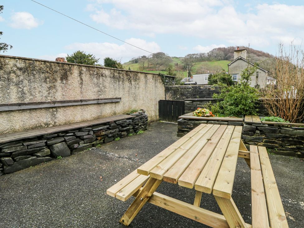 A picnic table and benches in a garden area at Yr Hen Ysgoldy